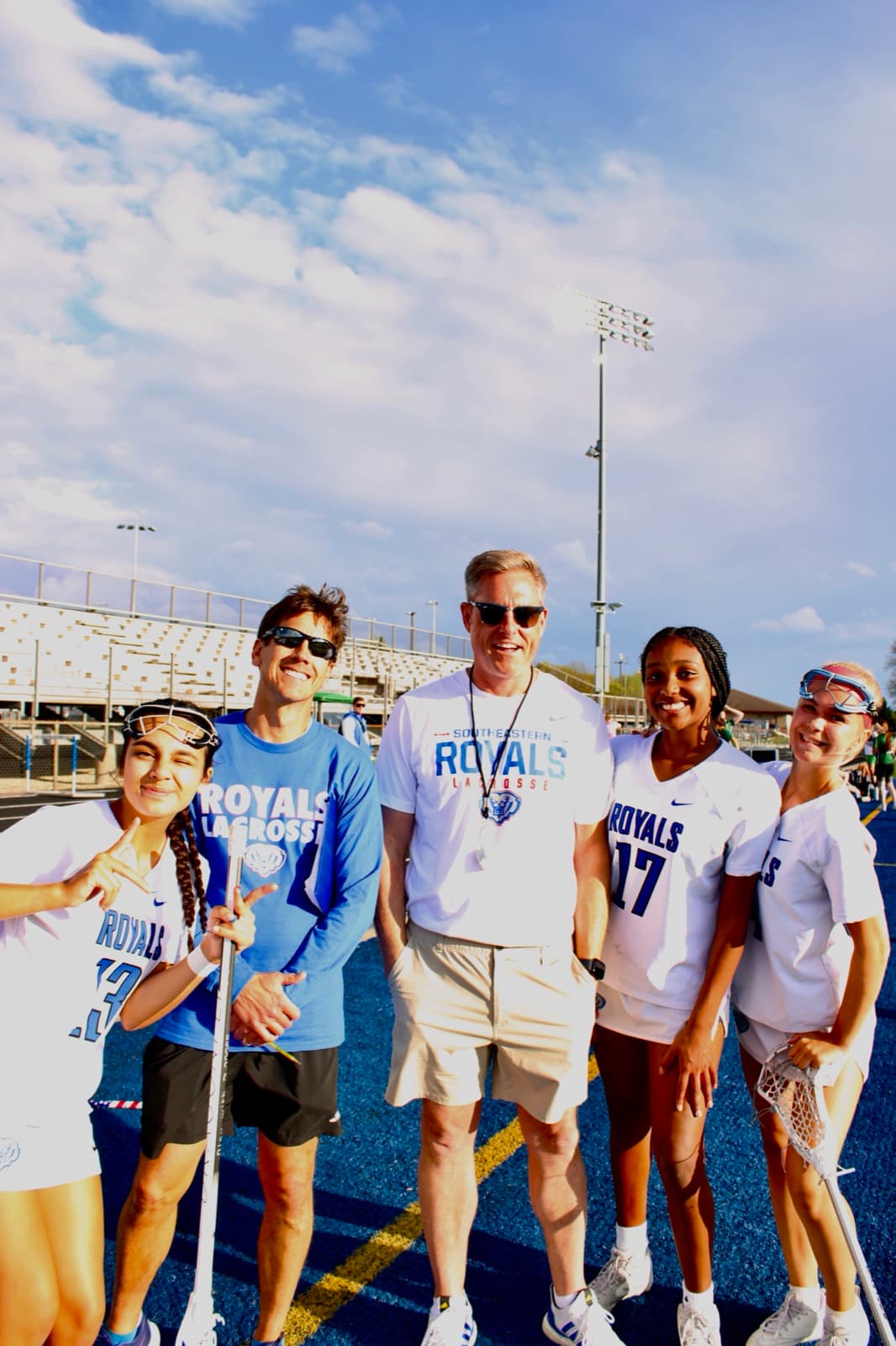 Greg with HSE Royals girls lacrosse players on the field.