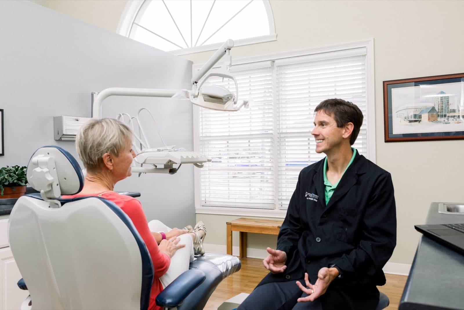 Dr. Greg Wright talking with a patient at his dental practice.