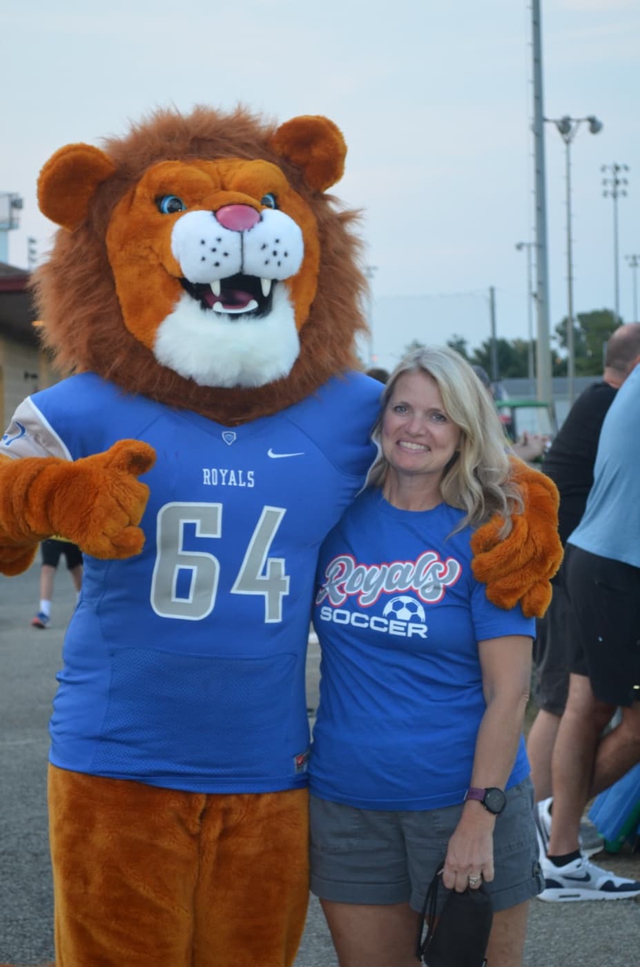 Charron Wright with the HSE Royals lion mascot at a soccer game.