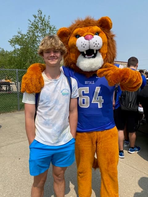 Logan Wright with the HSE Royals lion mascot.
