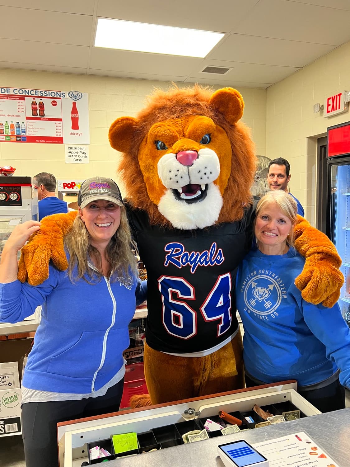 Charron Wright volunteering at the PTO-sponsored football concession stand with the HSE Royals mascot.